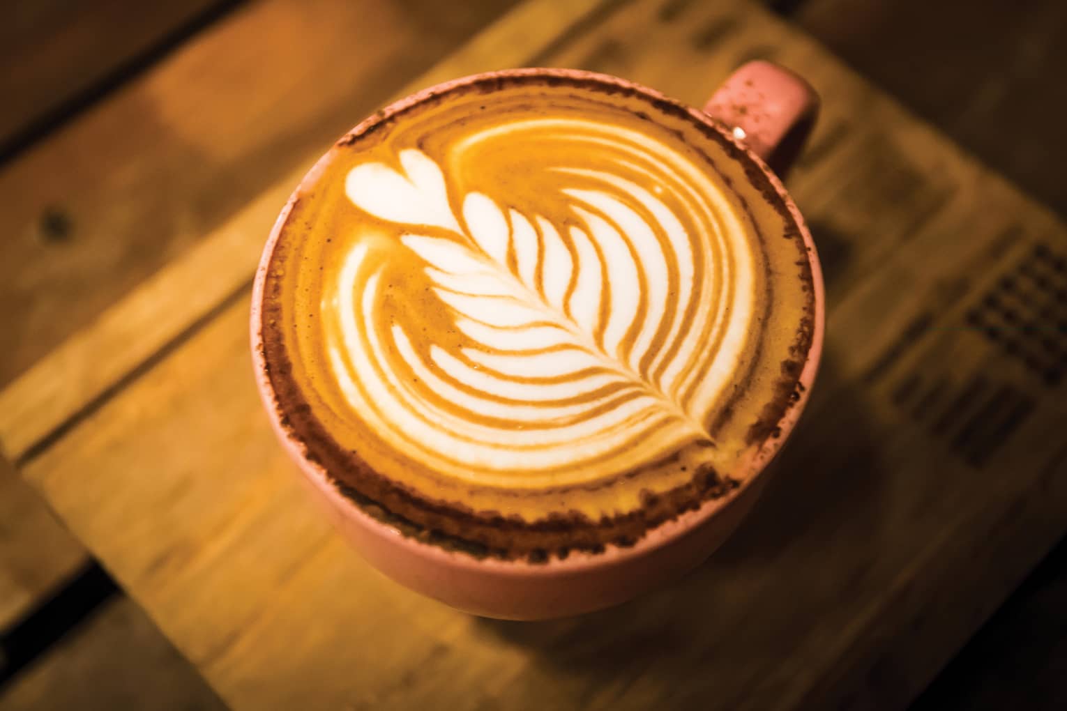 Close-up of latte coffee with flower design in foam