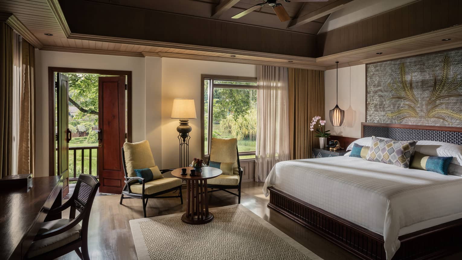 Upper Rice Terrace Pavilion Room bed, two yellow armchairs by sunny window, open patio door