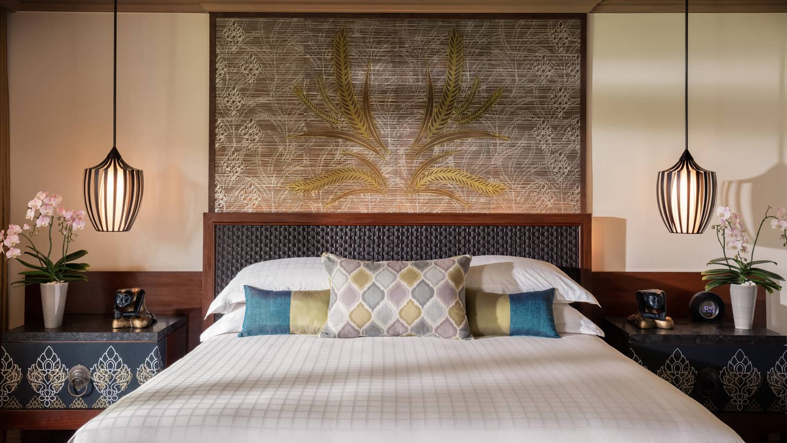 Upper Garden Pavilion room bed with blue-and-green accent pillows, large art, reading lights 