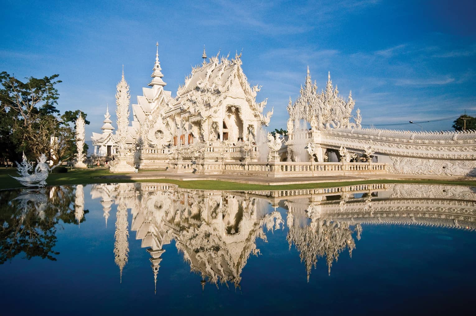 An ornate white castle reflecting in a pond