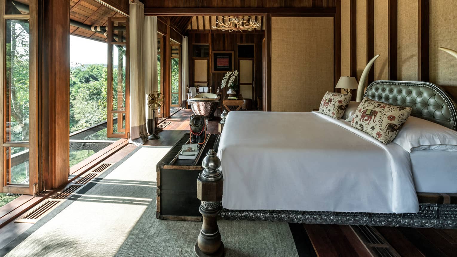 Two-bedroom Explorer's Lodge room bed in front of bright floor-to-ceiling windows