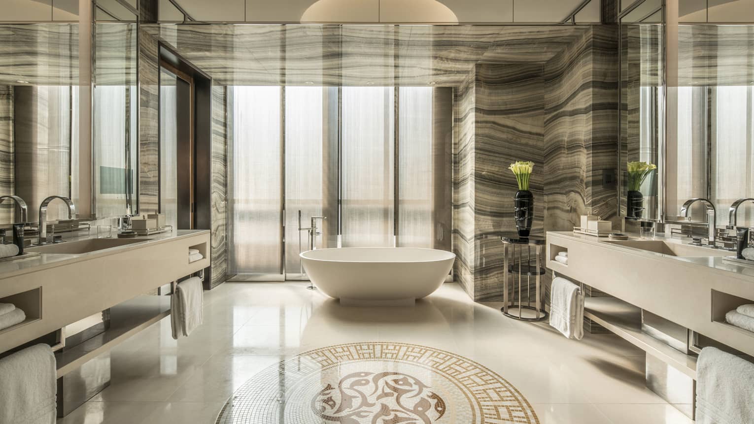 Deluxe One-Bedroom Suite large bathroom with marble, mosaic floors and walls, freestanding white tub