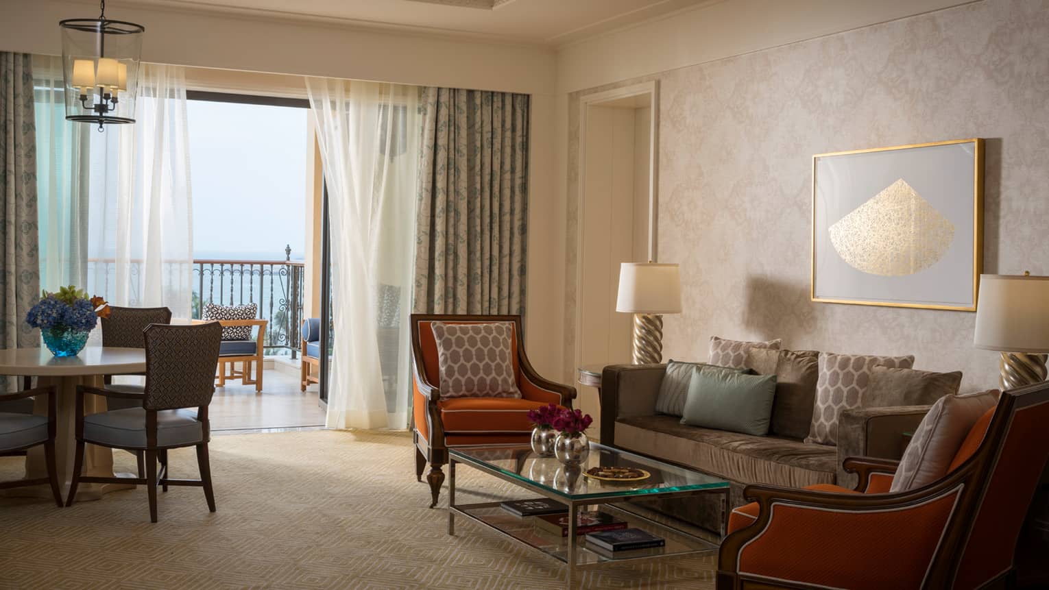 Jumeirah Sea-View Suite with large living space, orange and gold accents, white curtains