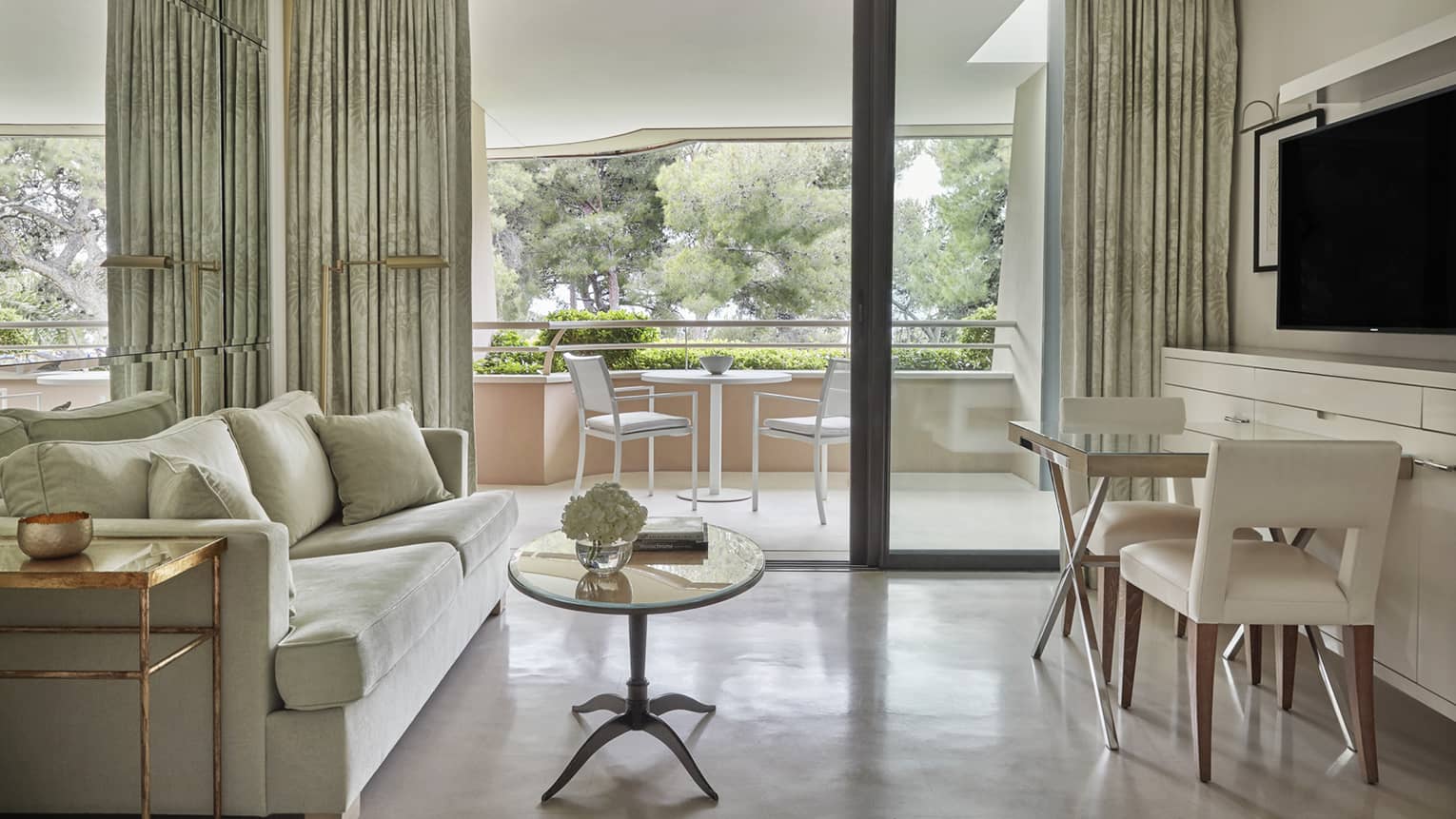 Neutral living room with coffee table, bistro set under TV, large patio doors, patio view