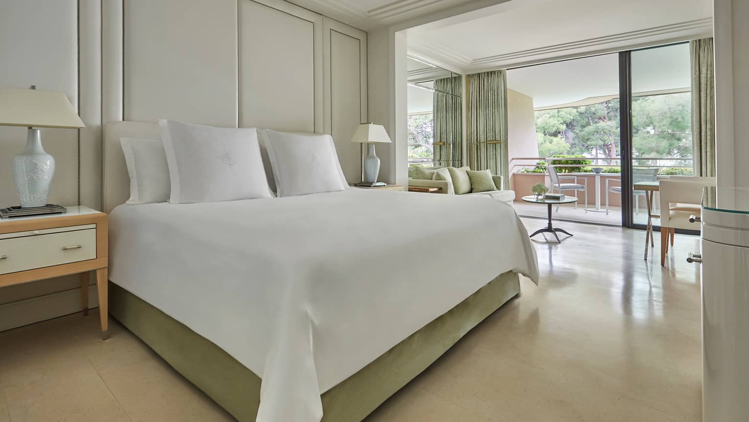Deluxe Terrace Room modern white hotel room with beds, lamps, open wall to patio