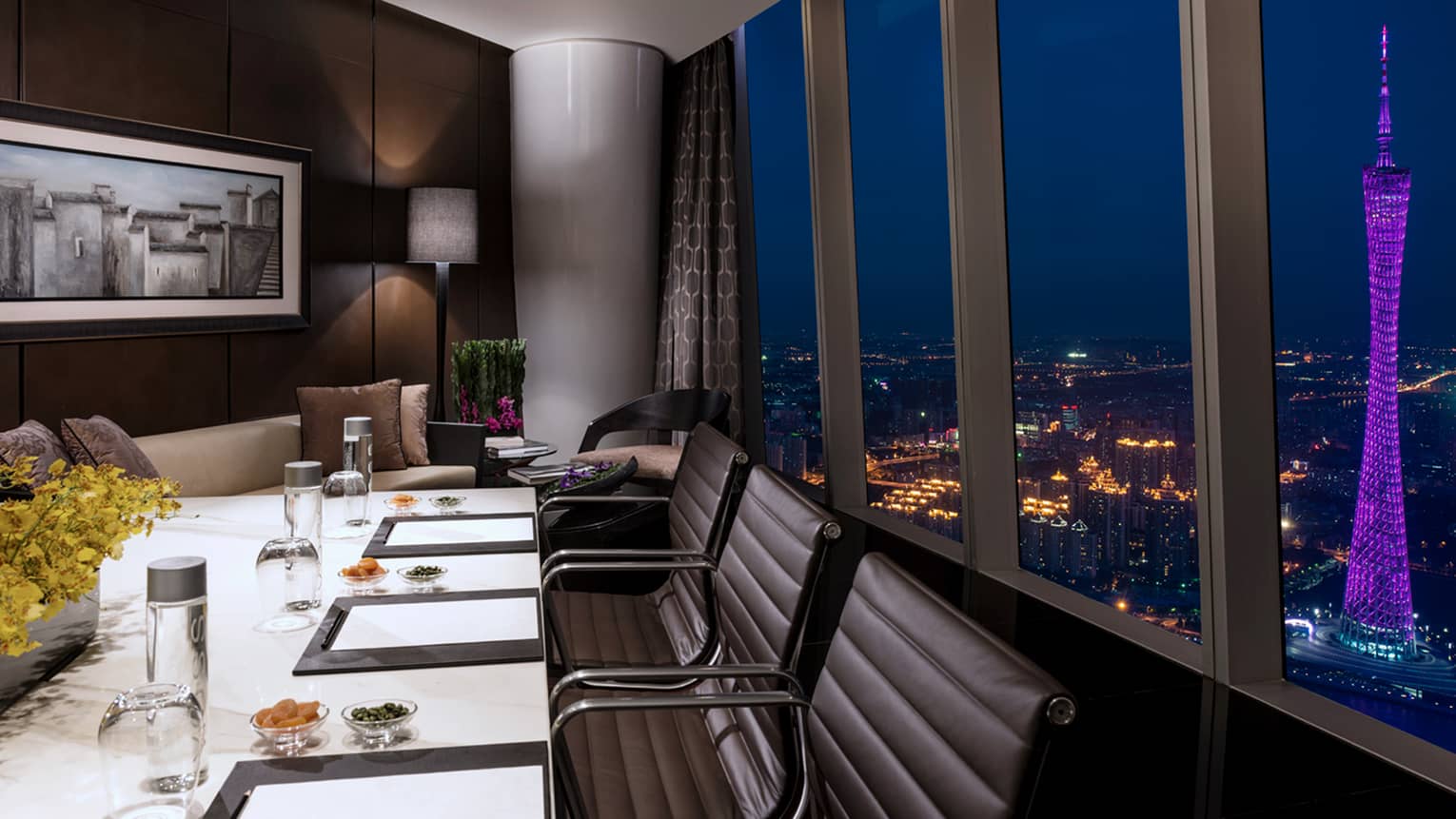 Executive Club private meeting table and sofa by window on 99th floor of hotel at night 