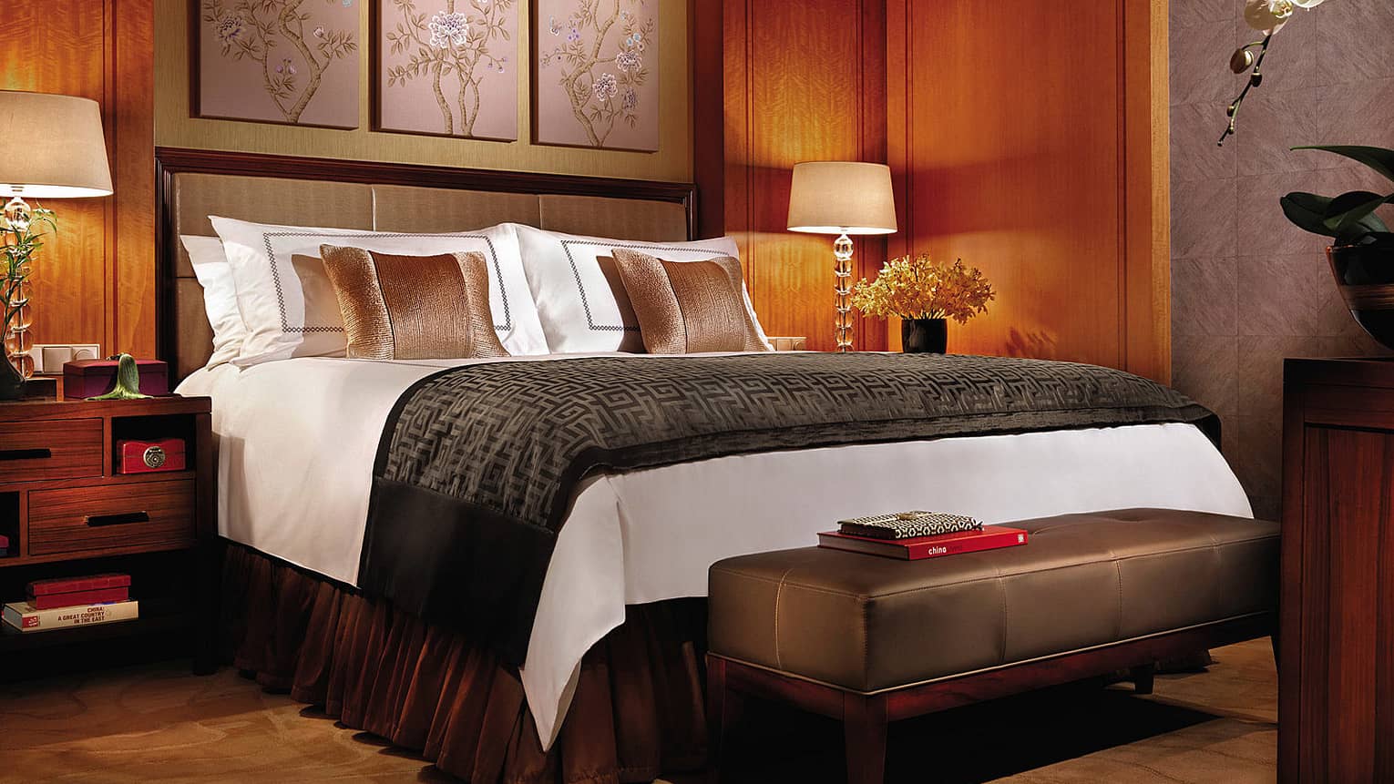 Deluxe Room hotel bed with dark brown, wood decor, traditional Chinese art