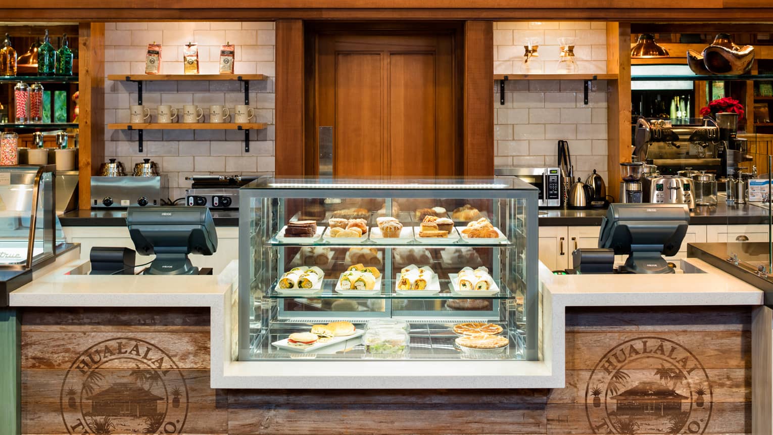 Hualalai Trading Company glass display with desserts at rustic wood counter