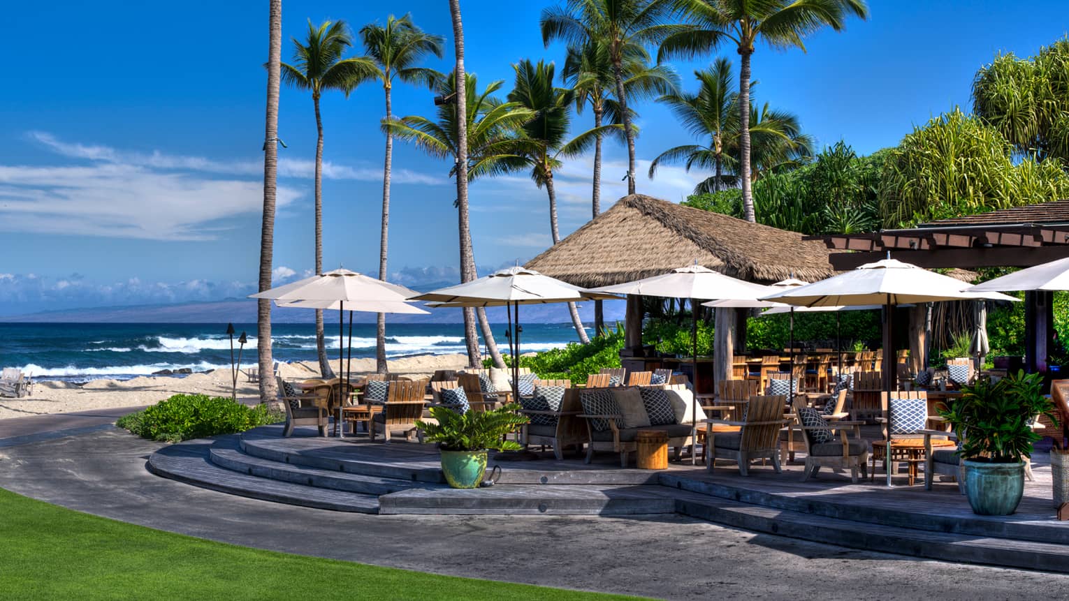 Beach Tree dining tables, chairs with cushions under patio tables, near ocean