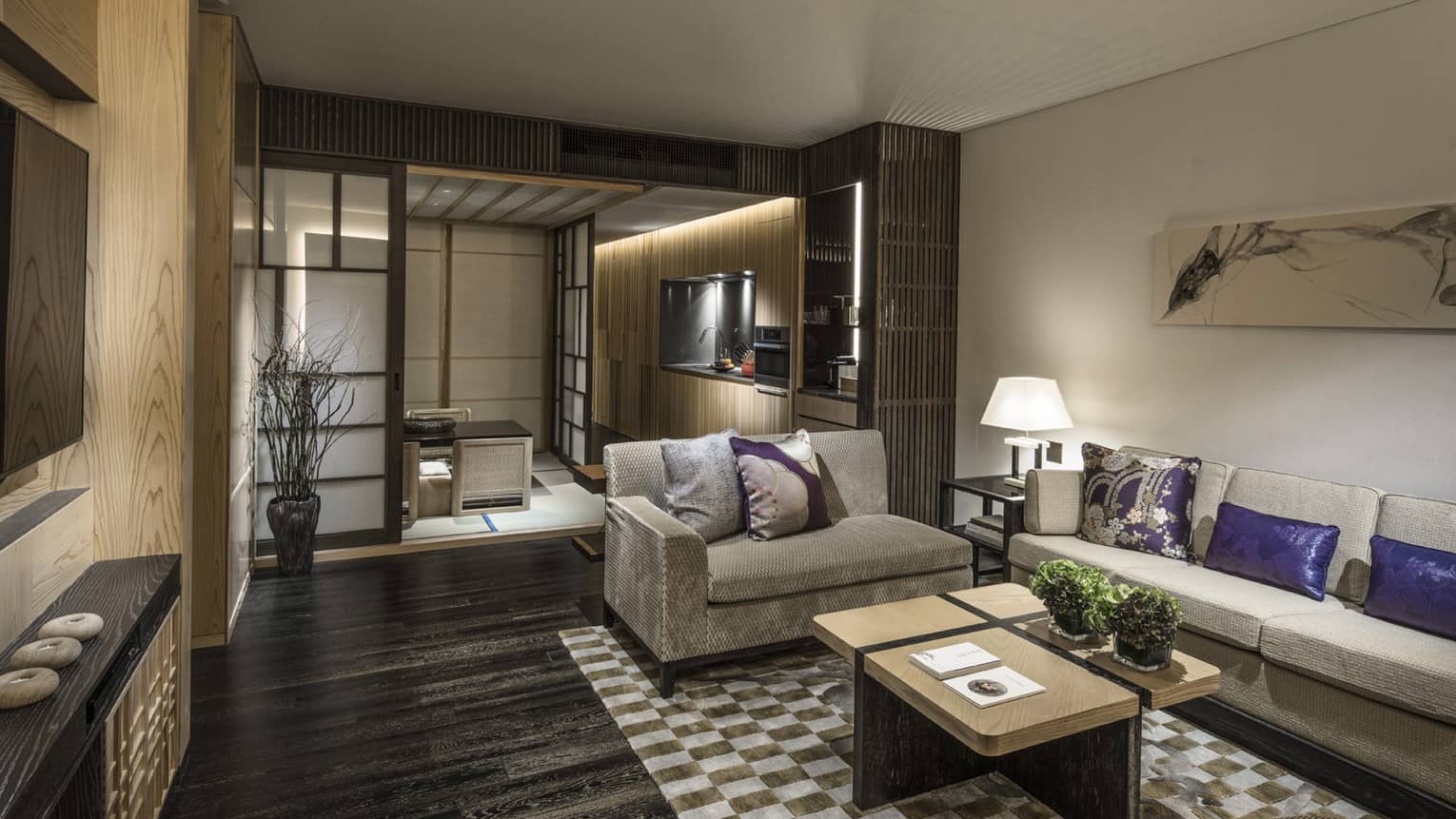 Dining residence with beige sofas, purple and beige cushions, kitchenette, coffee tables and traditional sliding doors leading to a tatami seating area