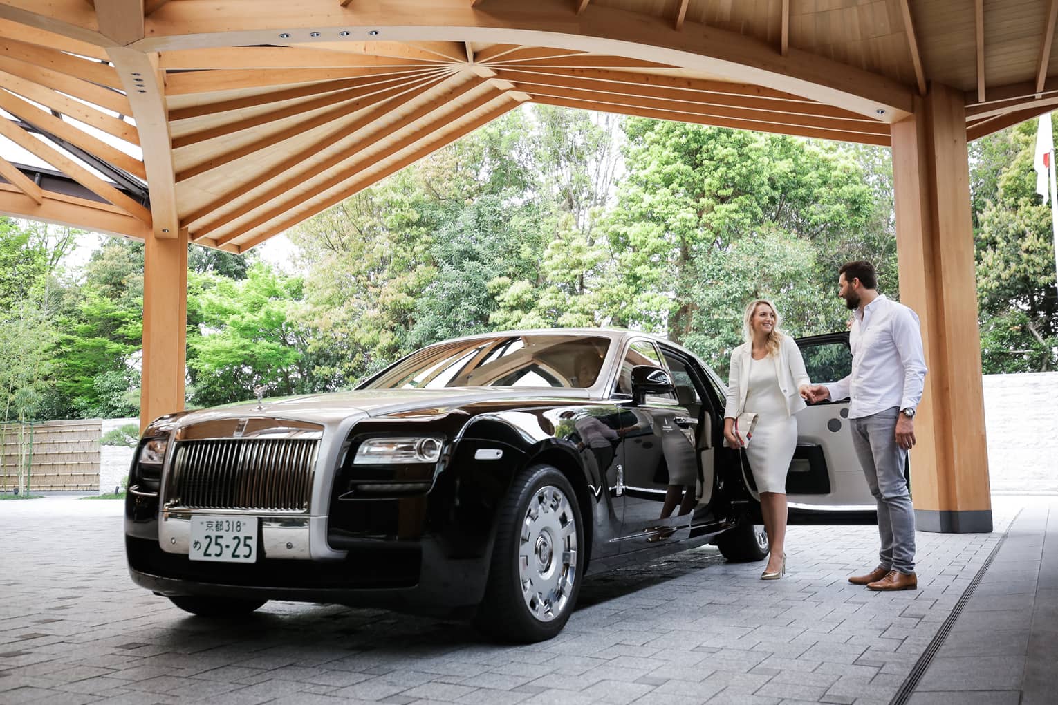 Couple exits black Bentley under awning at Four Seasons Hotel Kyoto