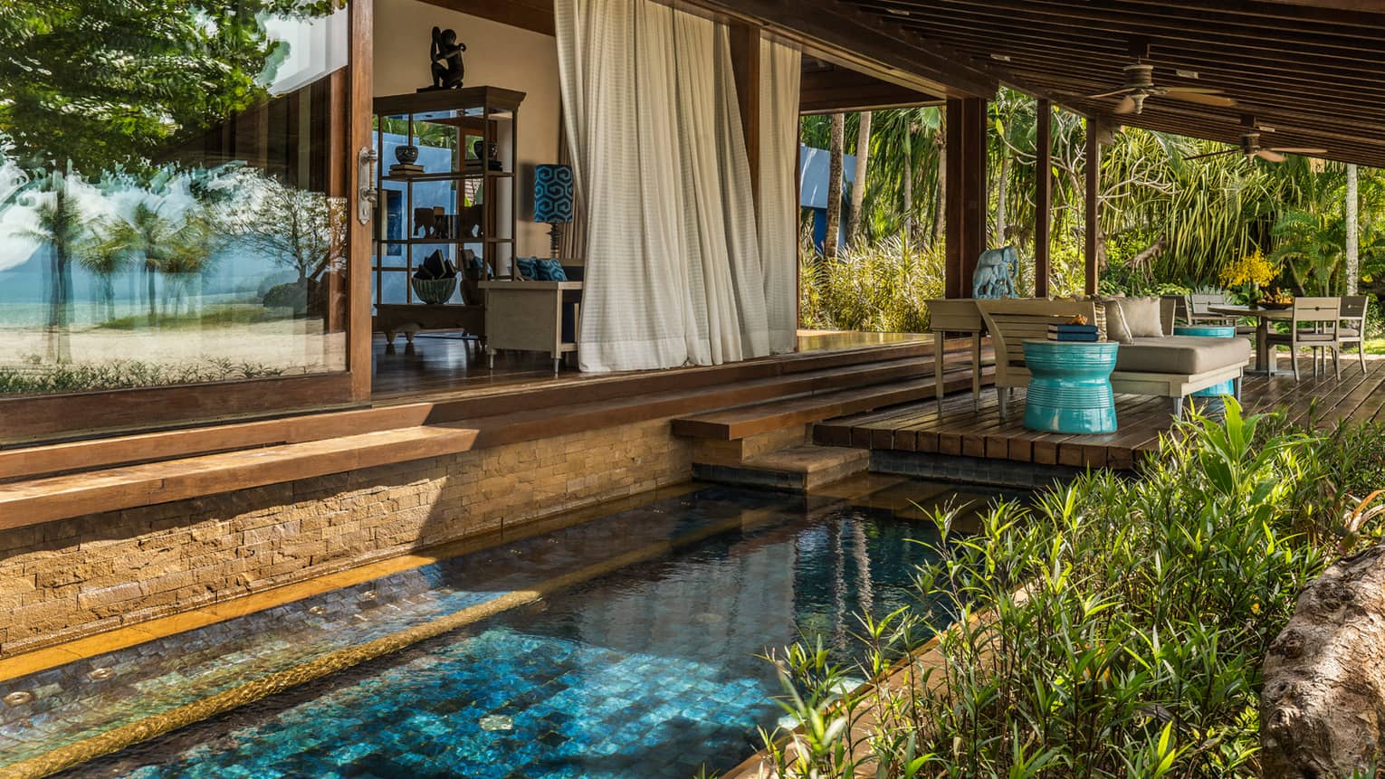 White curtains hang from Beach Villa patio over tile plunge pool