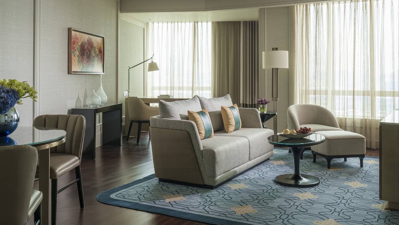 Executive Suite small sofa, armchair, ottoman and table by large windows, white curtains