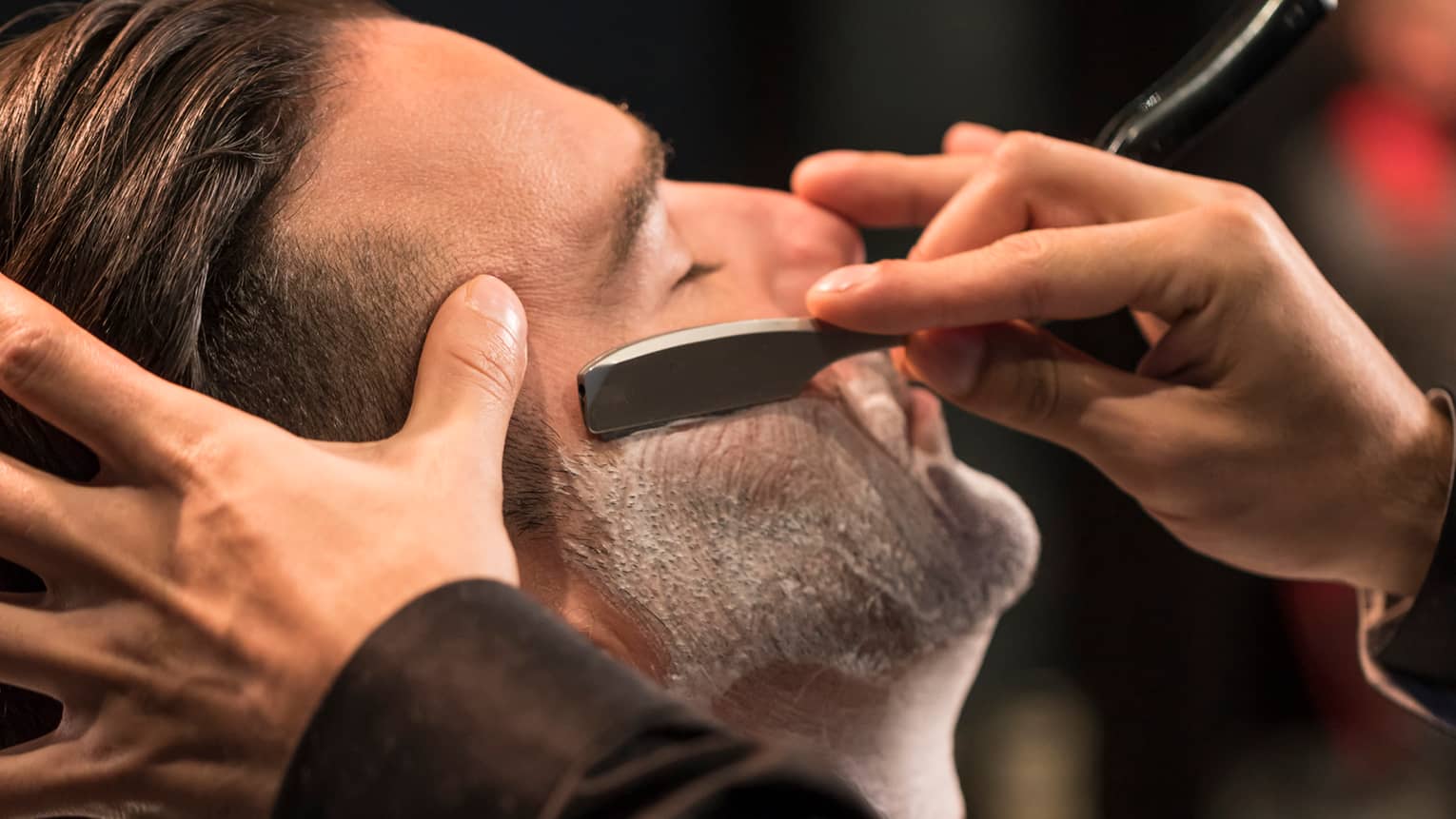 Close-up of man getting straight-razor shave in Gentlemen's Tonic barbershop