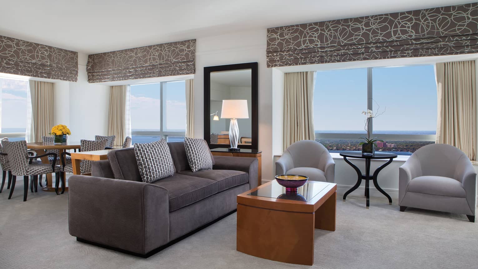 Grey sofa, armchairs in corner suite with large windows