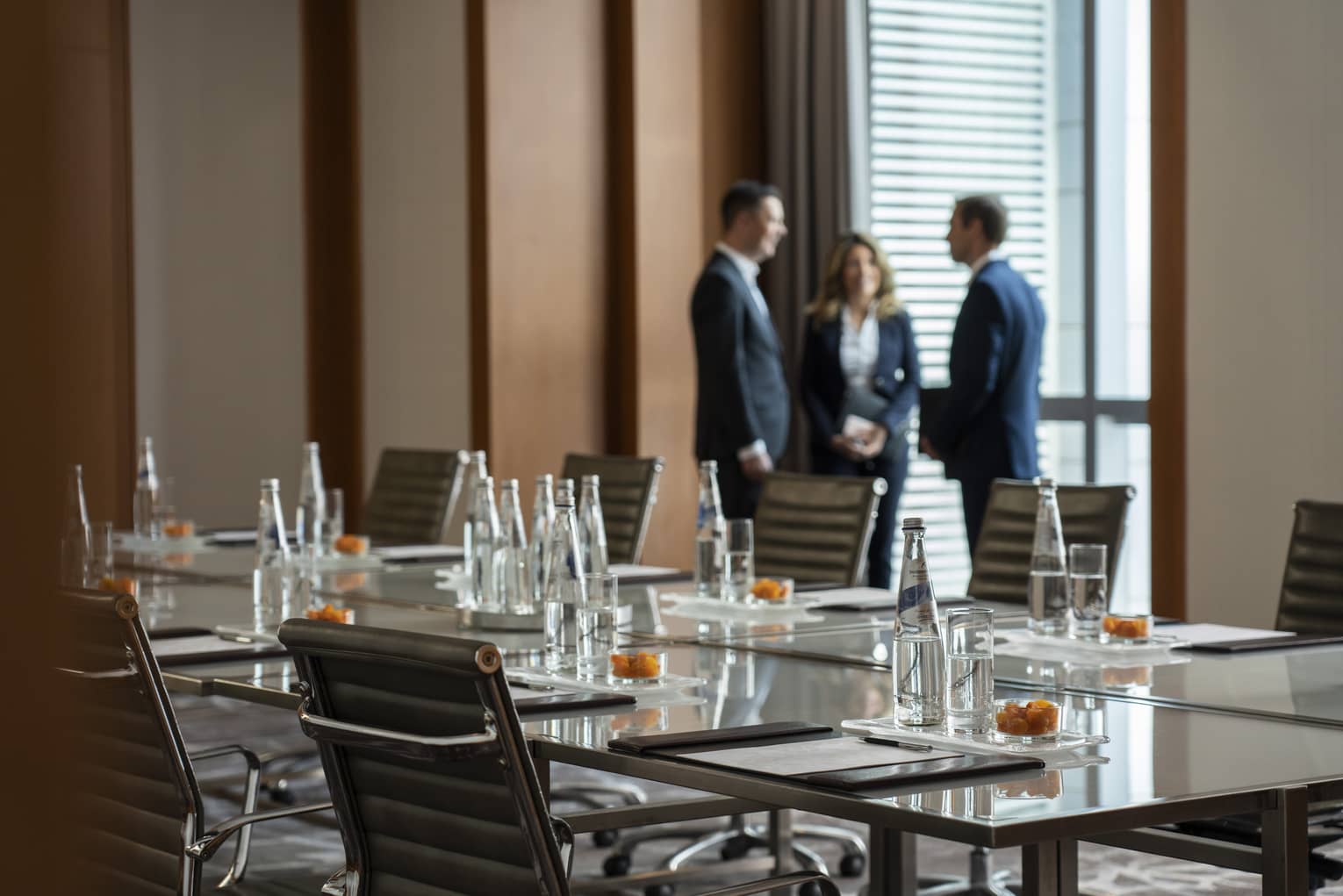 Three business people stand by window in Bal Harbour meeting room