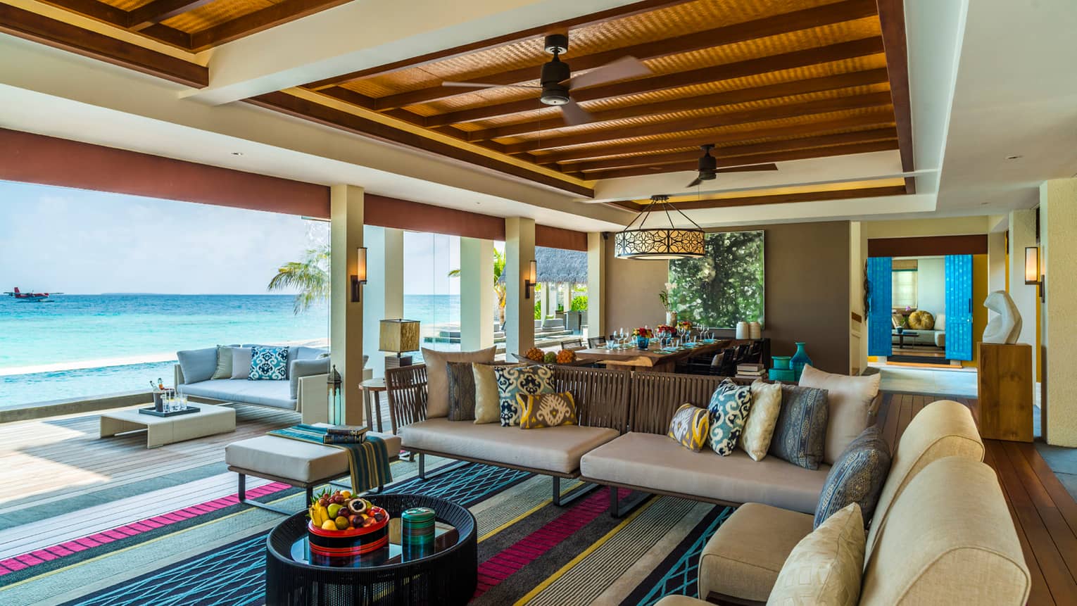 Three-Bedroom Landaa Estate open-air living room sofas, chairs looking out at ocean