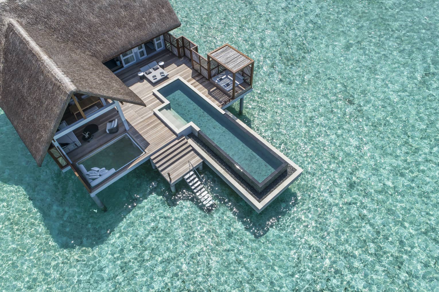 Aerial view of lure island villa with private pool and deck surrounded by crystal ocean