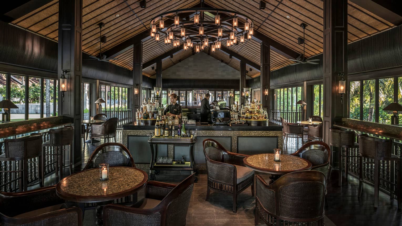 Bartenders at The Bar under cathedral ceiling with large lantern chandelier