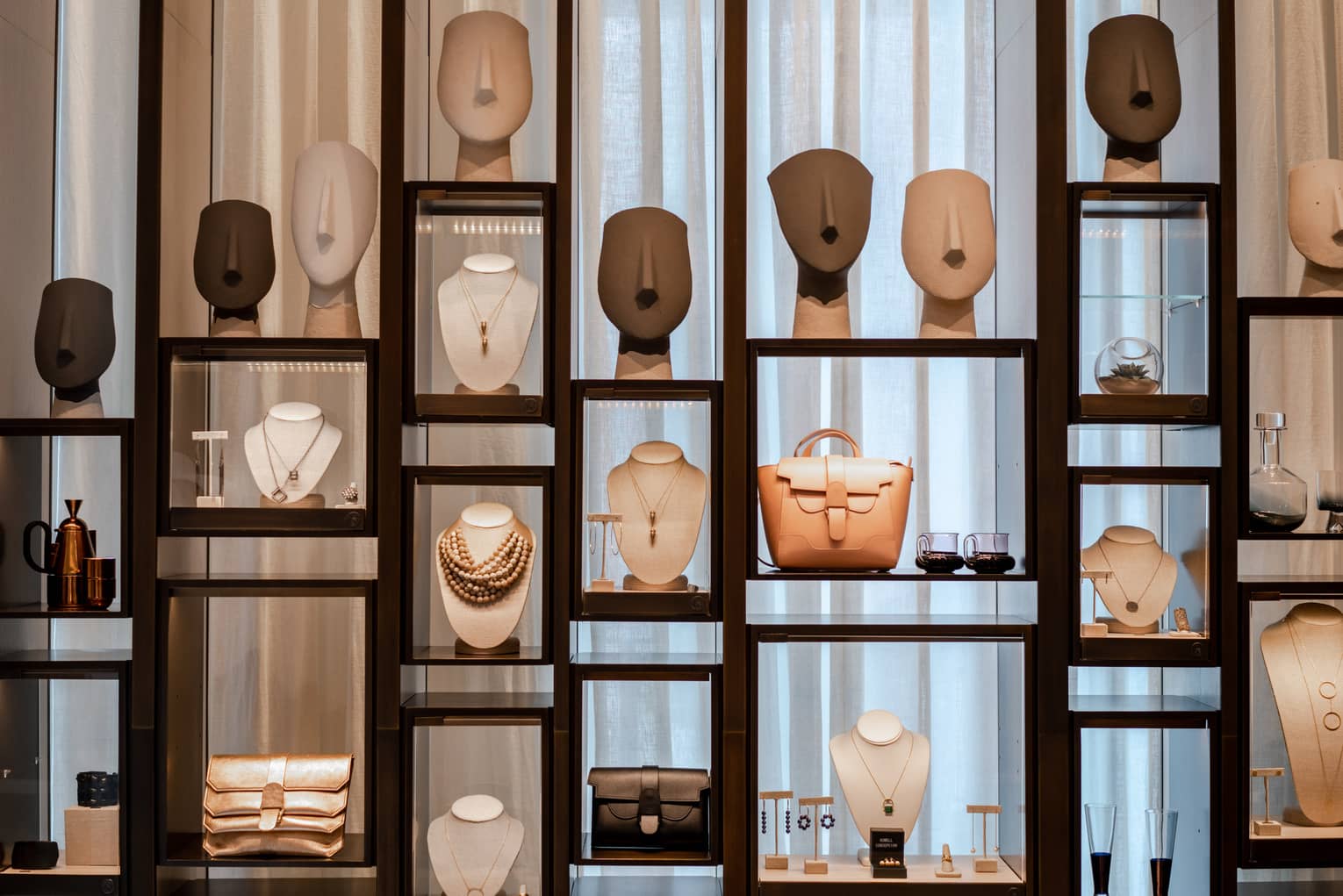 Wooden and glass display case with merchandise like jewelry and handbags
