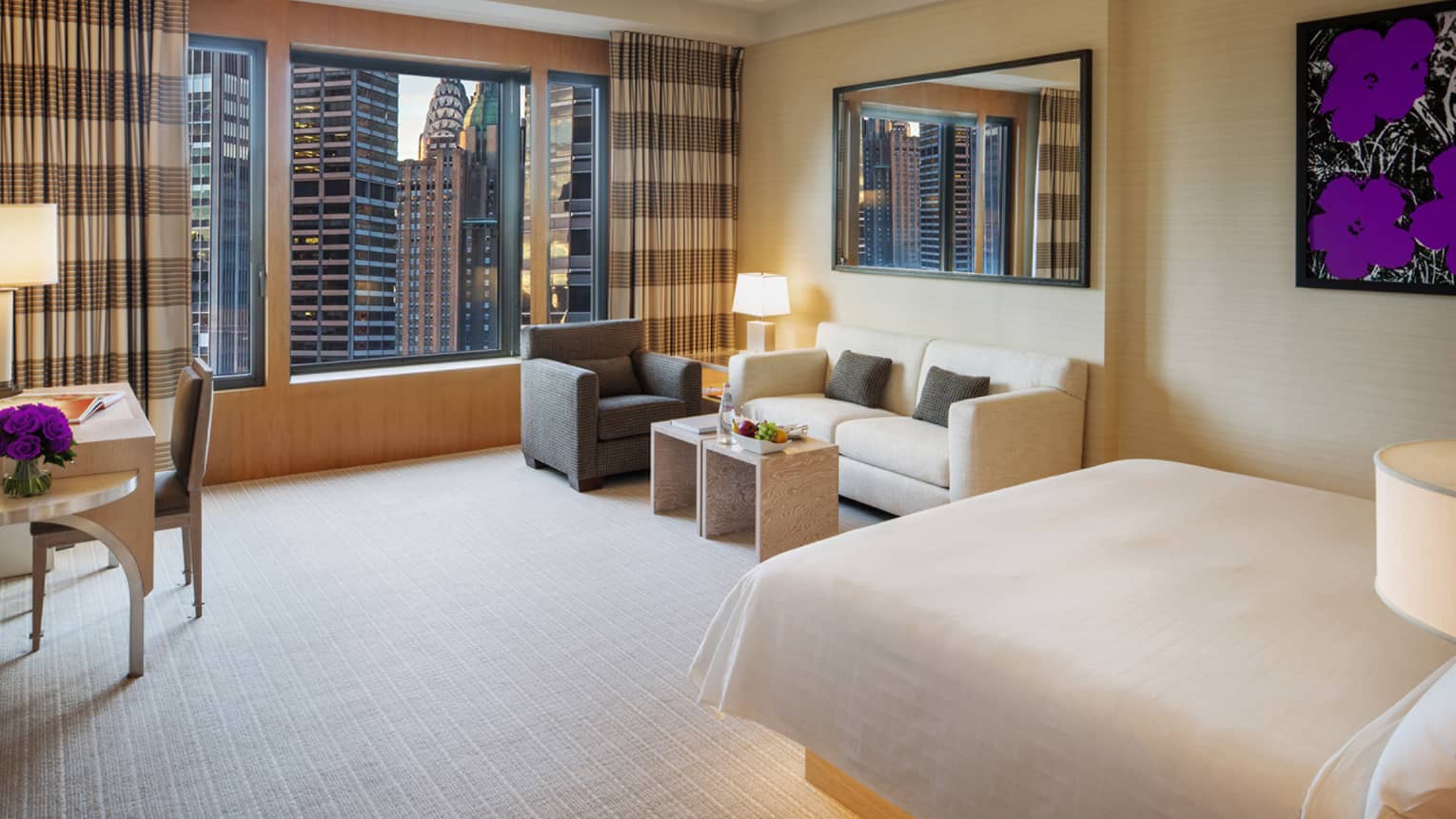 Manhattan Junior Suite bed with illuminated base, small sofa and armchair in corner by large window