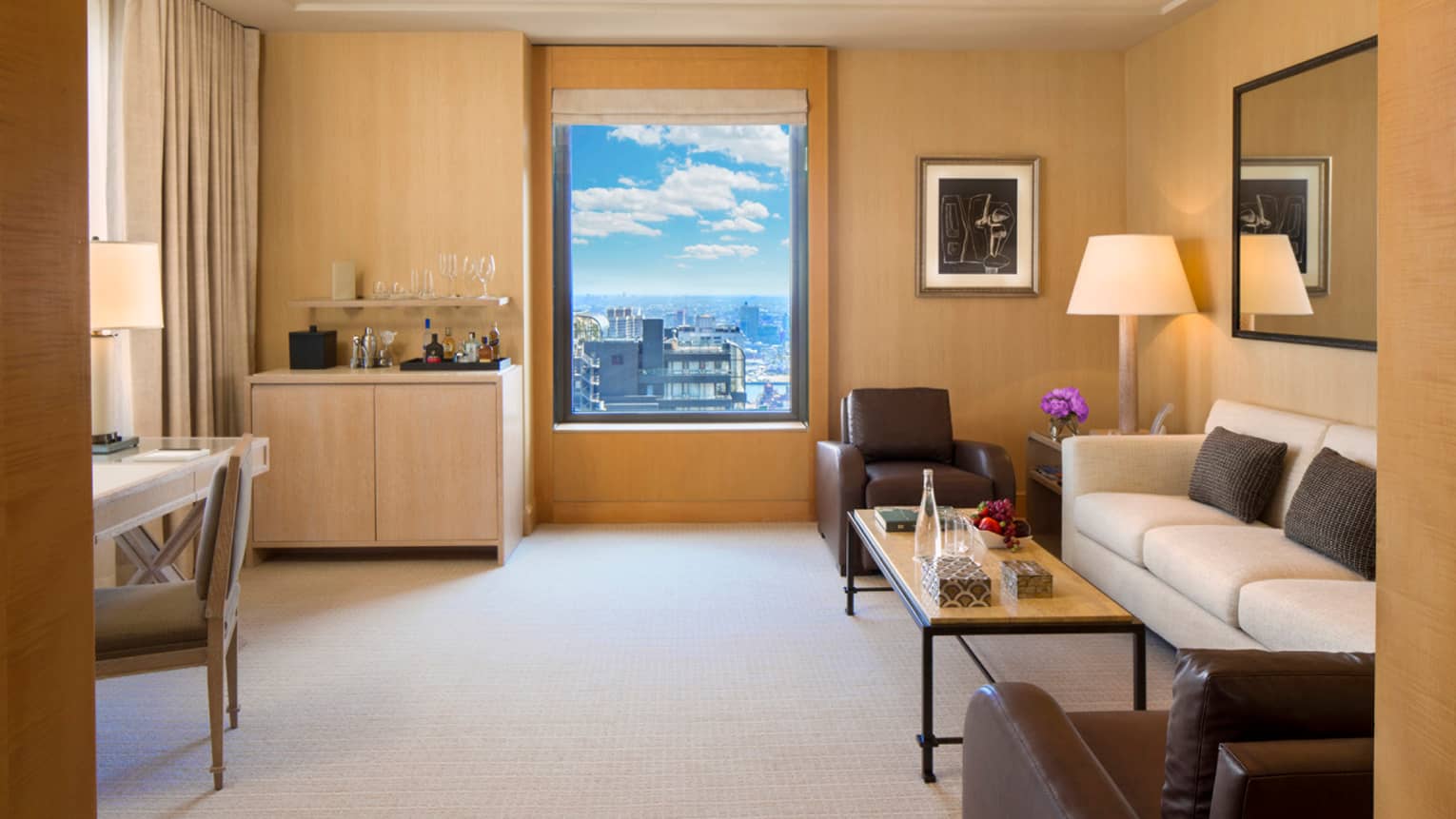 Park Avenue Suite small wet bar by window, white sofa with two brown leather chairs
