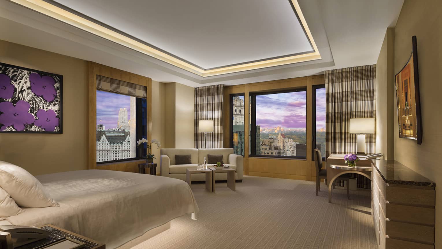 Manhattan Junior Suite bed across from small sofa and desk, window with city park views 