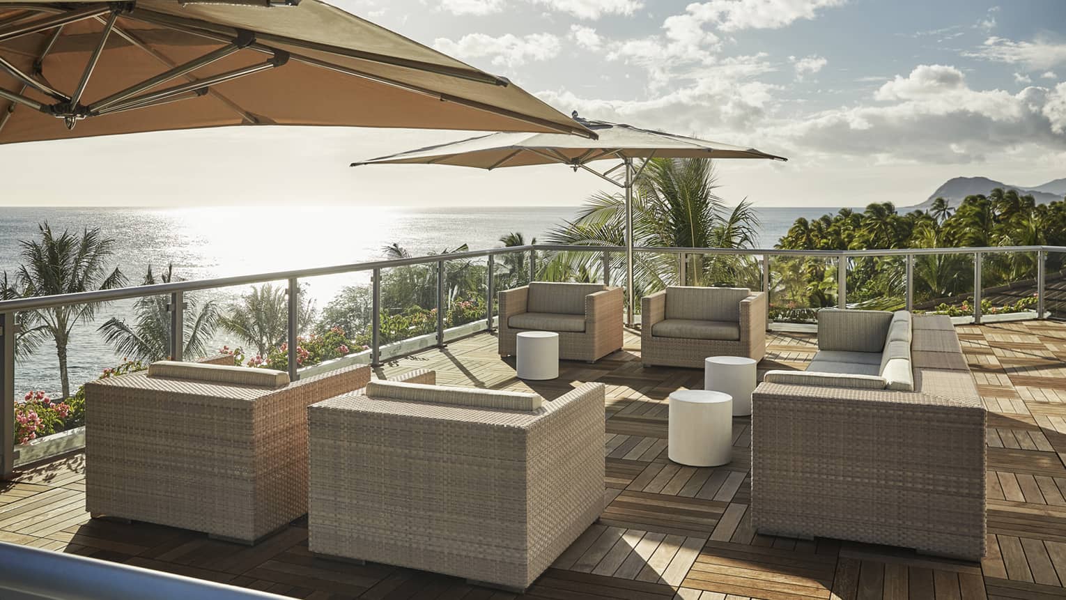 Presidential Suite patio with large wicker chairs, parquet floors, umbrellas, ocean view