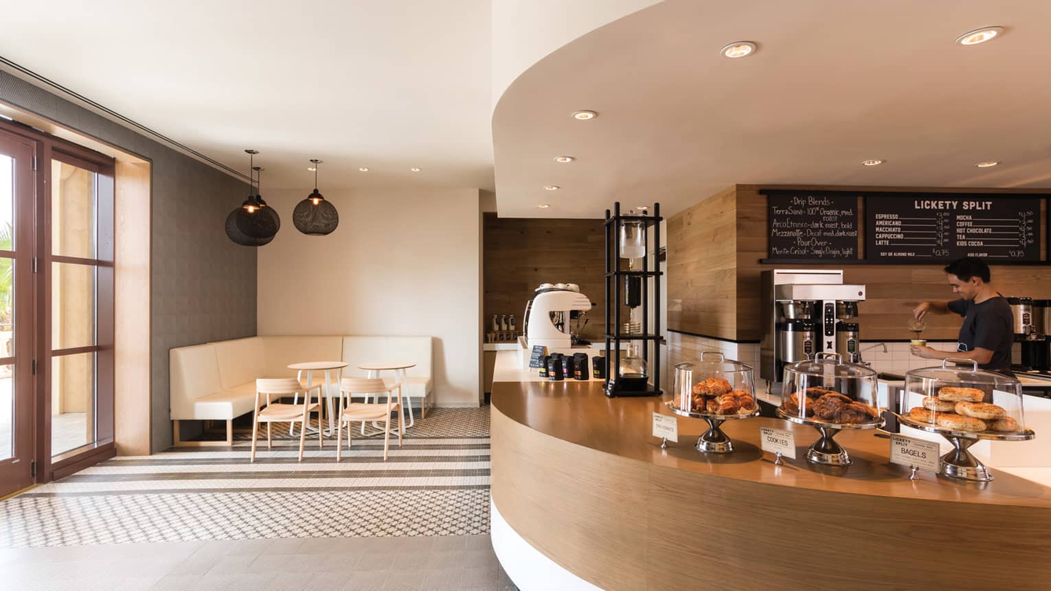 Curved wood desk at Lickety Split bakery with fresh pastries under glass displays, coffee station