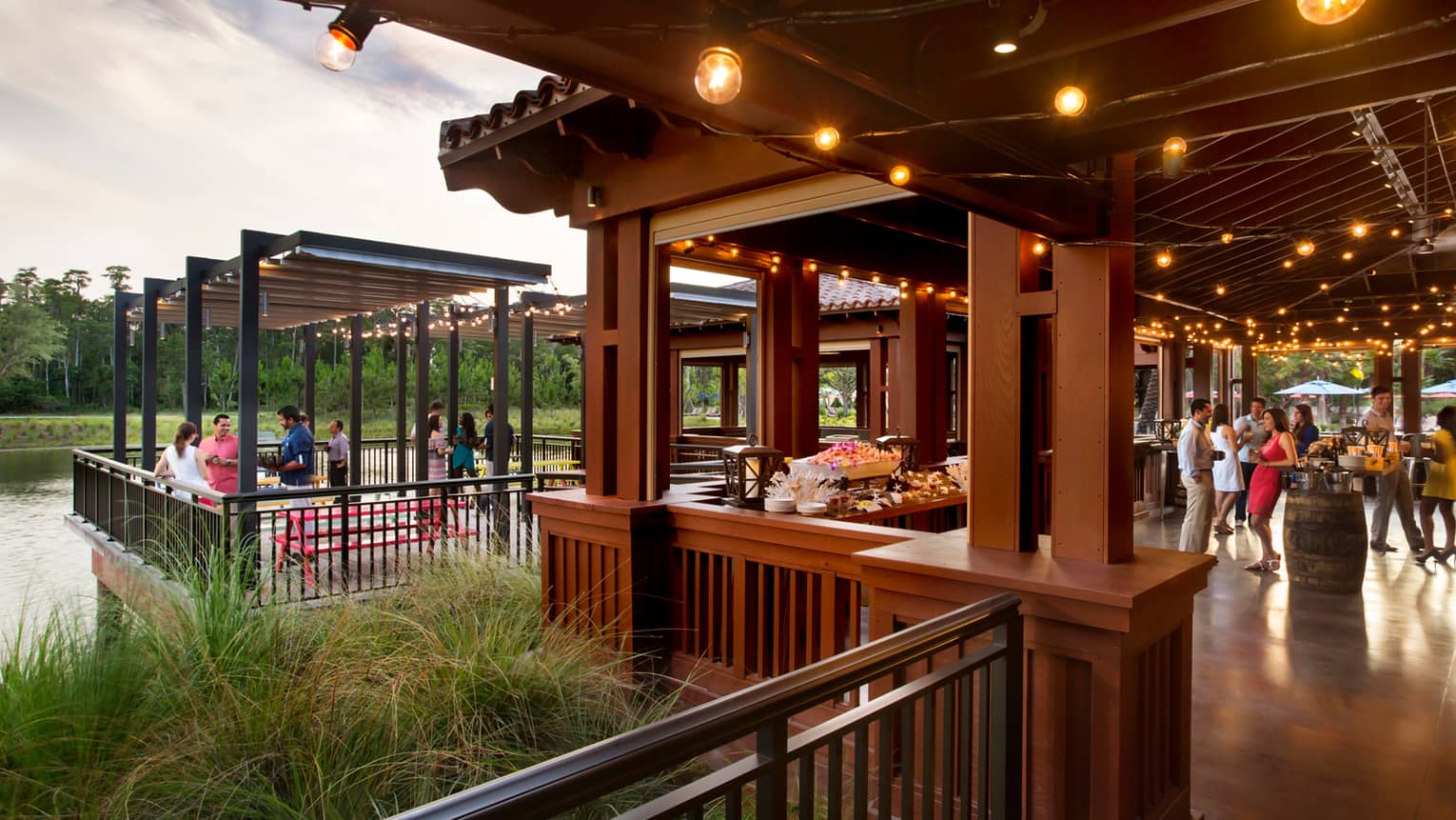 PB and G restaurant, people socializing under covered wood patio with lights
