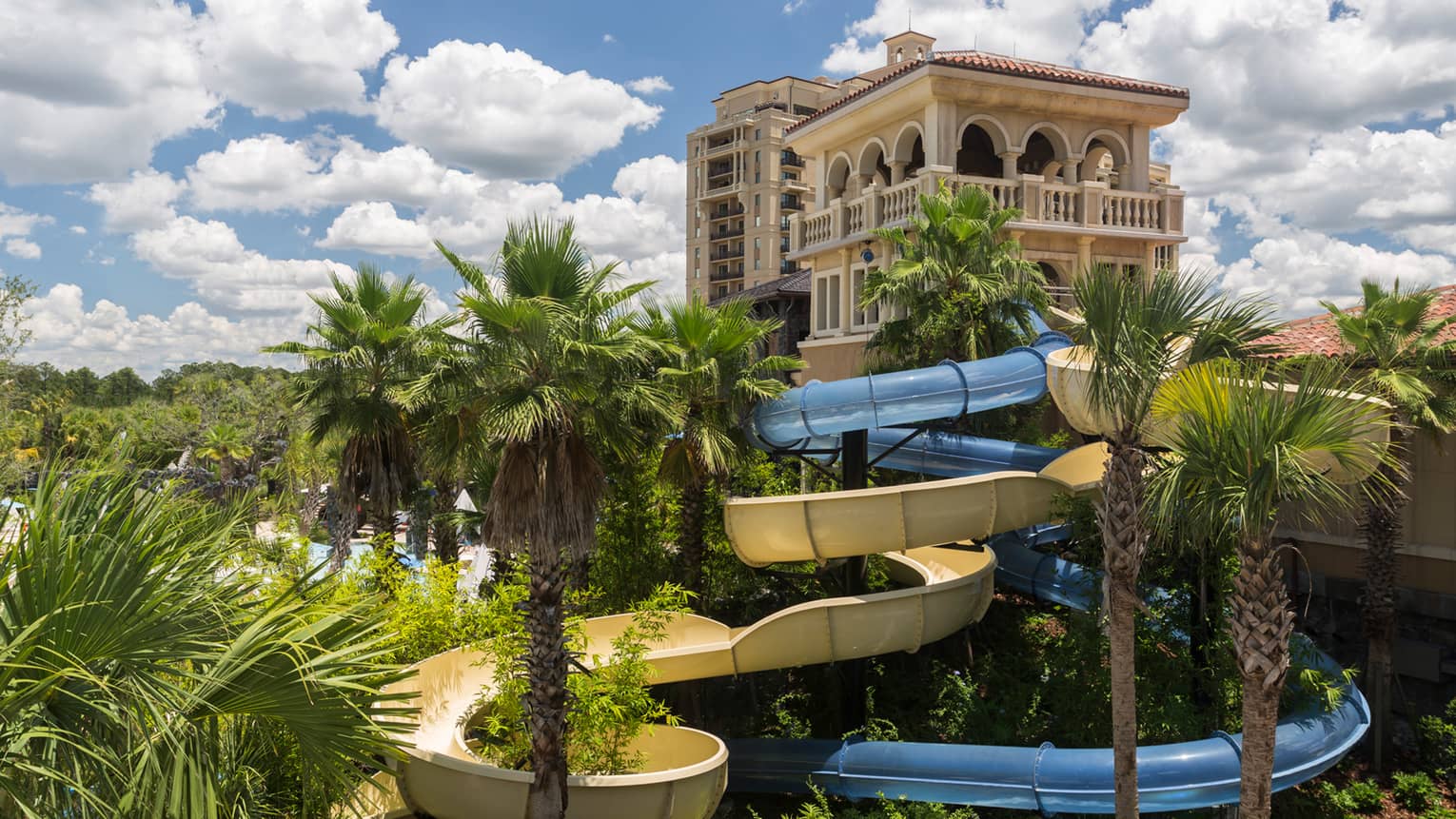Building over winding outdoor water slide, palm trees
