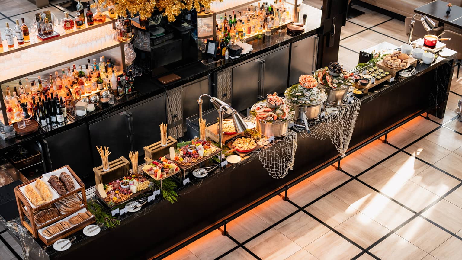 An expansive brunch buffet served on a black marble bar - charcuterie, seafood, breads and sandwiches 