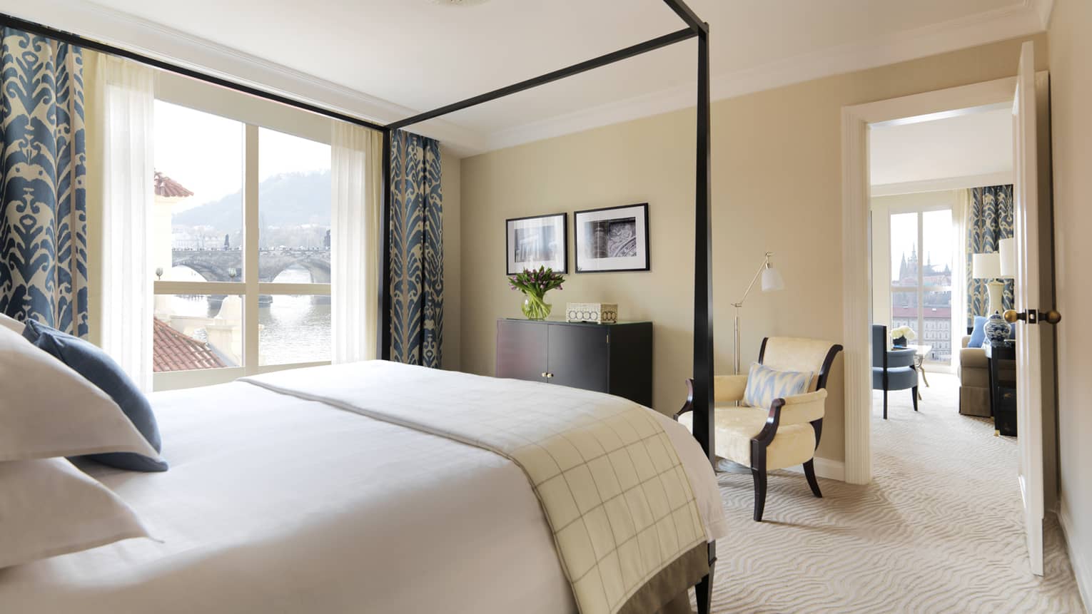 River Suite with modern ivory-coloured decor with blue accents on curtains, pillows, canopy bed frame