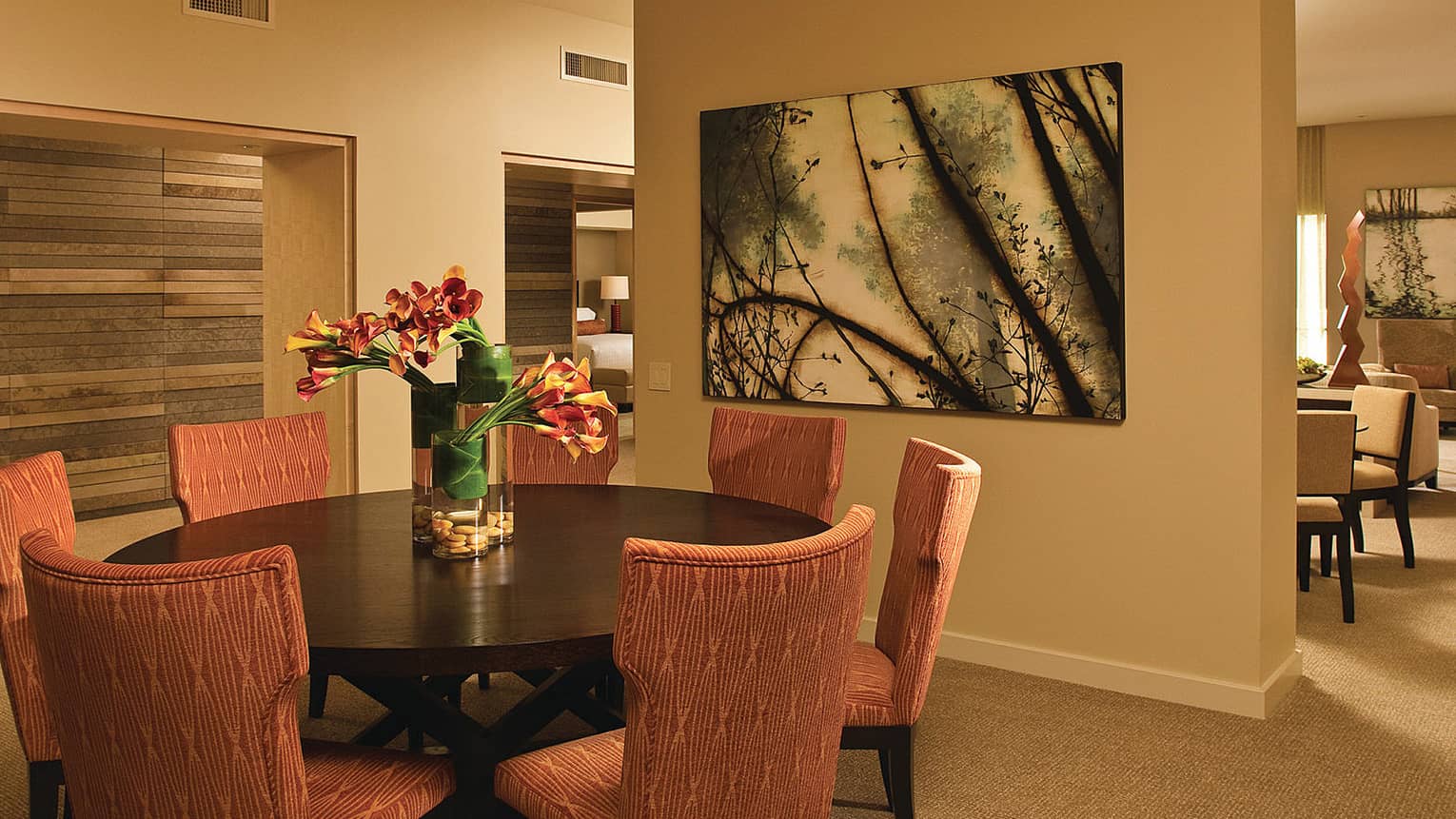 Presidential Suite dining table with red upholstered dining chairs, wood panel accent wall, art
