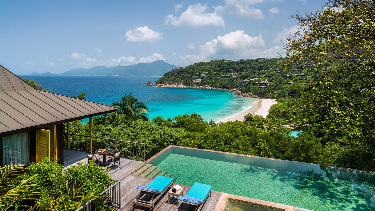 Aerial view of Two-Bedroom Ocean-View Suite pool, chairs and deck, mountain and ocean views
