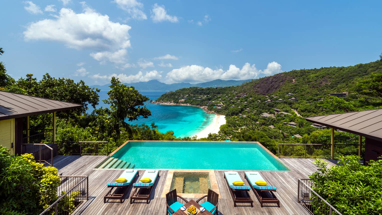 Two-Bedroom Hilltop Ocean-View Suite patio, four lounge chairs on deck by pool, hot tub, overlooking mountains, ocean