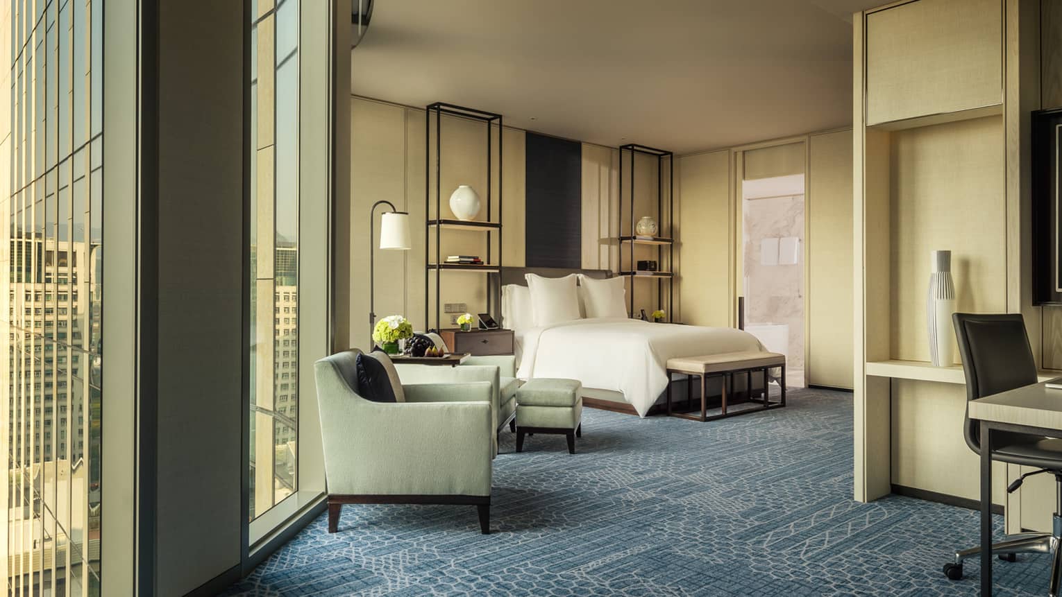 Studio Suite armchairs by tall windows, hotel bed, alcove with work desk