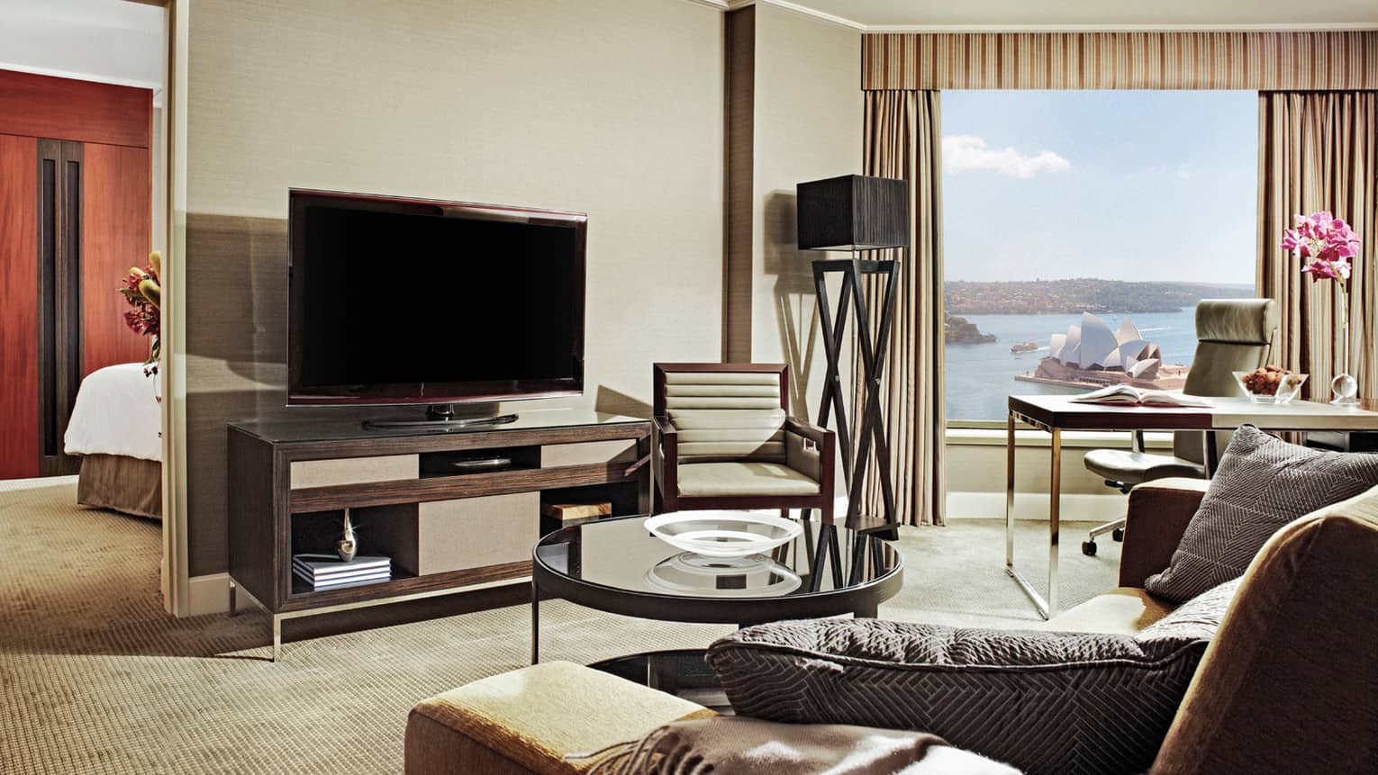 Club Full Harbour-Suite View sofa, glass table by TV, bedroom door, desk by window