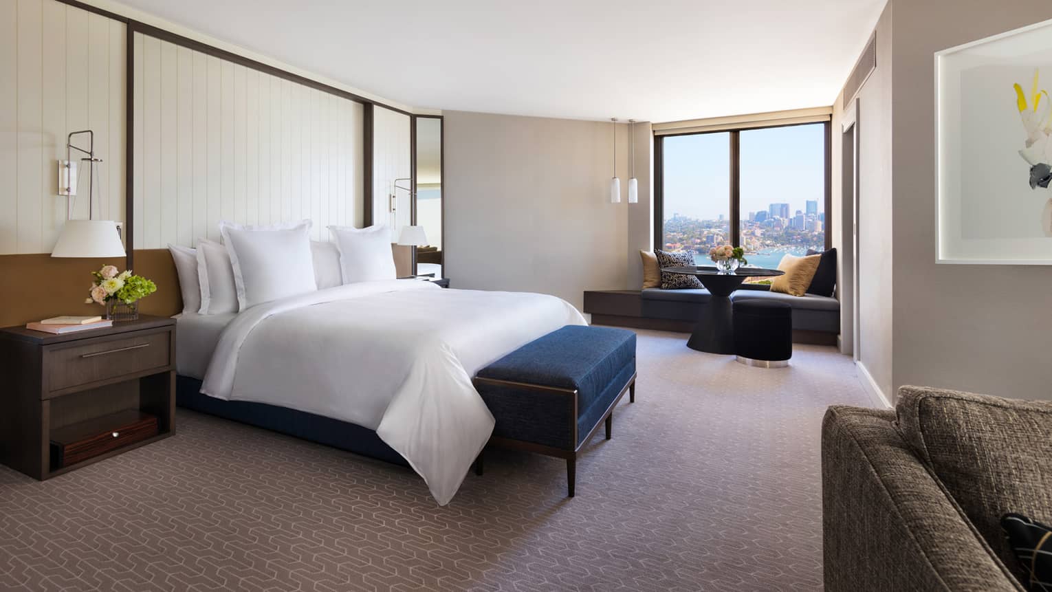 Spacious hotel room with king bed and partial views of Sydney Harbour