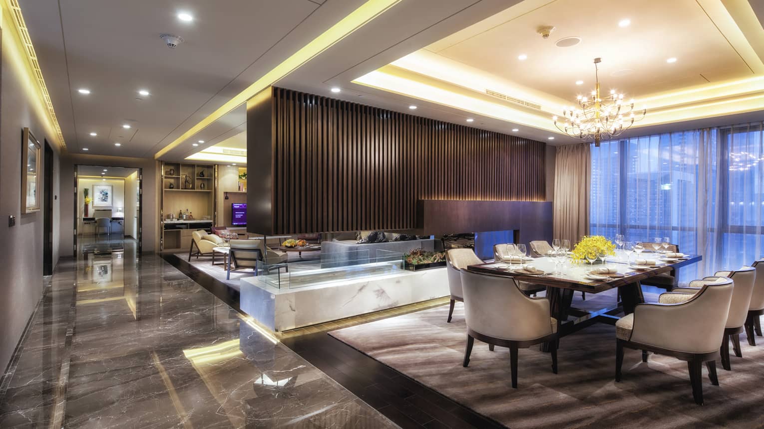 Presidential Suite large dining room, modern wood fireplace separating living room, marble floors