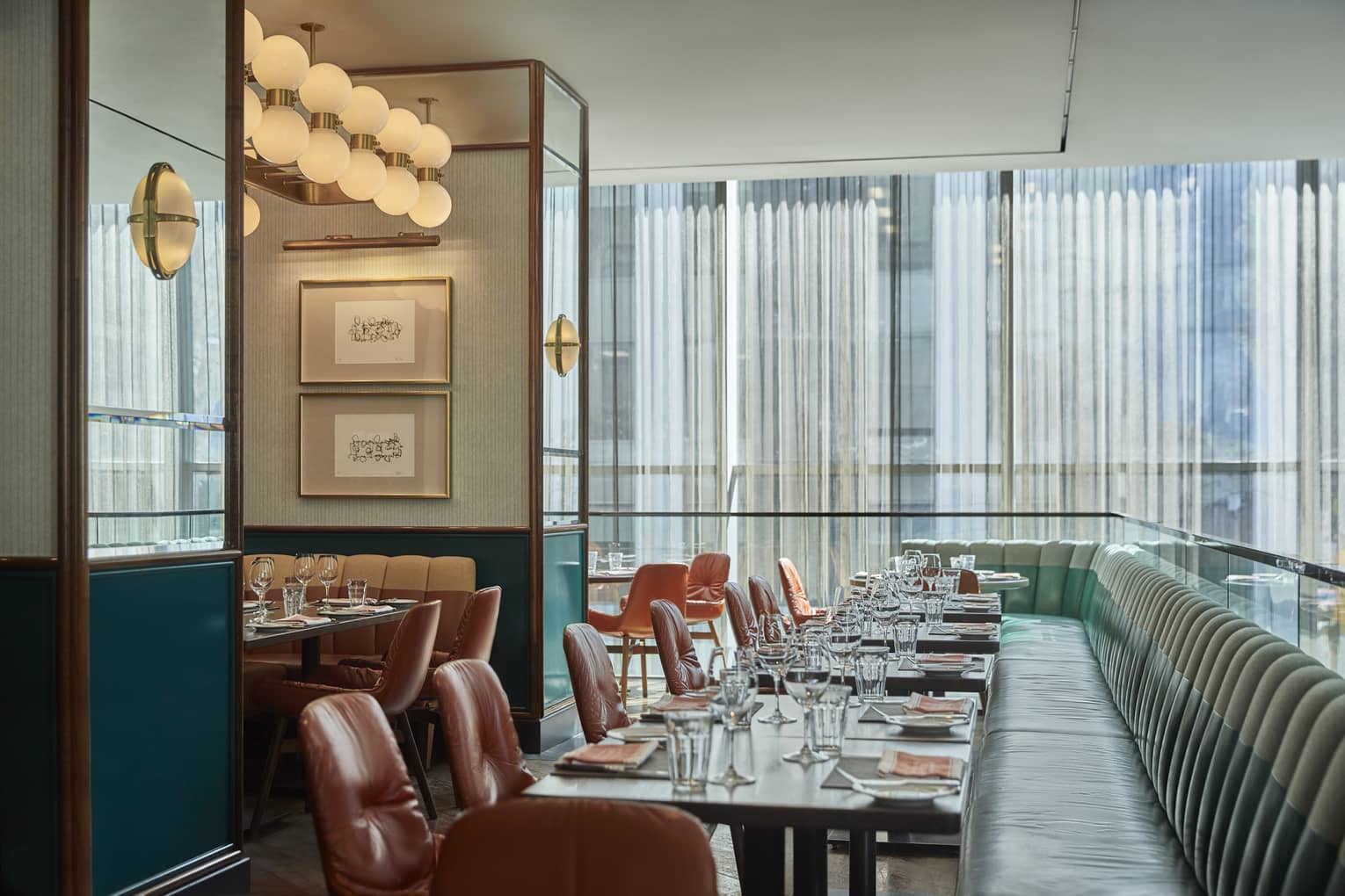 Blue upholstered sofas and brown chairs at a set table, floor length windows, round lights
