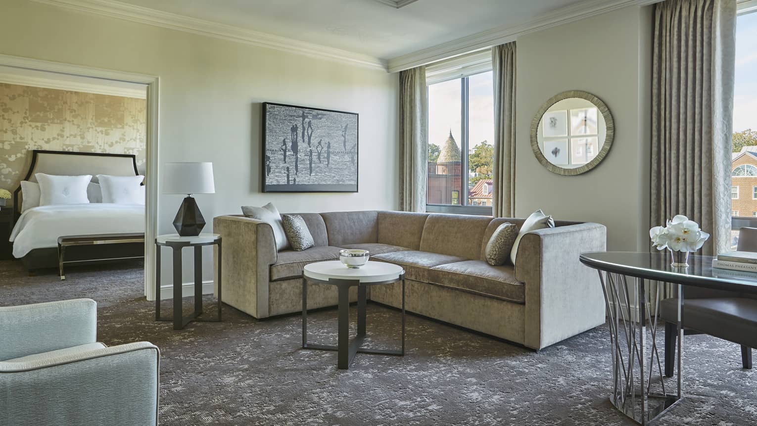 Georgetown One-Bedroom Suite L-shaped grey sofa between door to bedroom, large picture windows, work desk