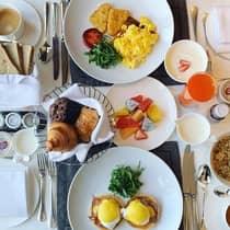 Aerial view of a table filled with various breakfast dishes and beverages