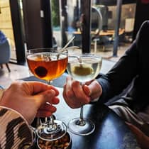 ,Two people enjoy chilled cocktails at a restaurant 