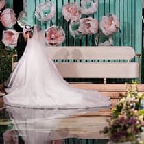 A bride and groom stand in an ornately decorated venue