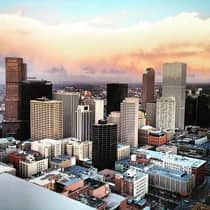 Sunset reflected in clouds behind Denver city skyline, buildings