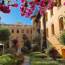 Pink flowers on tree over garden courtyard, hotel