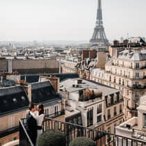 Couple embracing on Paris Hotel terrace with Eiffel Tower view
