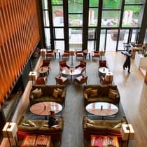 Aerial view of dining room under tall orange wall, windows
