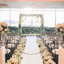 Wedding ceremony set-up, bouquets of flowers along aisle leading to altar with lanterns by window